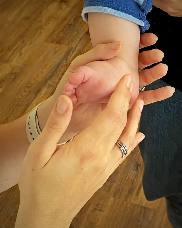 Gentle reflexology on a newborn baby’s foot
